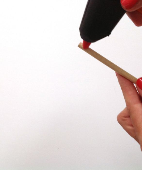 Prendete un bastoncino e arrotolate sulla punta per circa 2 cm l’estremità del filo ancora libera, dopo aver messo della colla a caldo per farlo aderire.