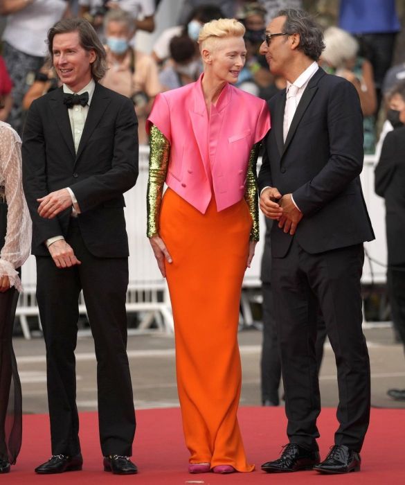 <p>Mondana, ma oltremondana: il fascino etereo di Tilda Swinton appartiene a un’altra galassia, lo sappiamo bene. A <strong>Cannes 2021</strong> omaggia <strong>David Bowie</strong> con un look a tutto colore, in controtendenza rispetto al nero e agli altri colori "classici" imperanti: <strong>blazer cropped doppiopetto</strong> a maniche corte rosa salmone, gonna lunga arancio e lunghe maniche tempestate di paillettes dorate. Un outfit iconico, firmato <strong>Haider Ackerman</strong>.</p>
