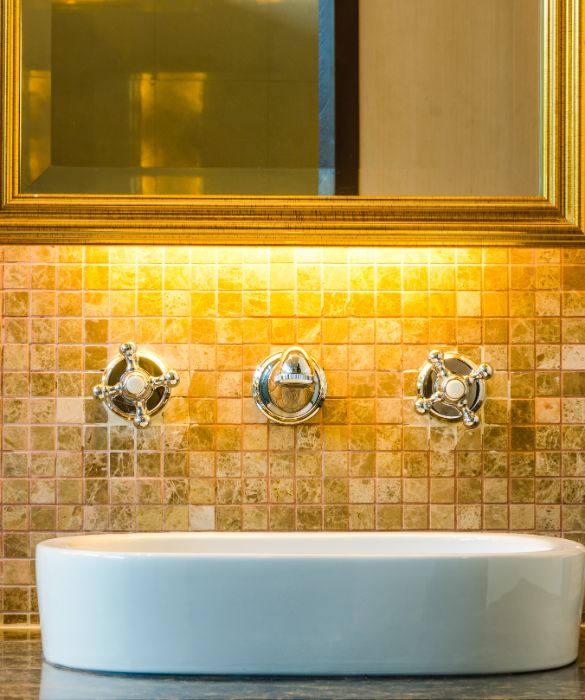 Se avete una casa grande e almeno due bagni, arredatene uno in maniera speciale. Scegliete piastrelle o tessere di mosaico sui toni dell'oro e abbinateli a specchi e arredi eleganti. Sarà un perfetto bagno per gli ospiti.