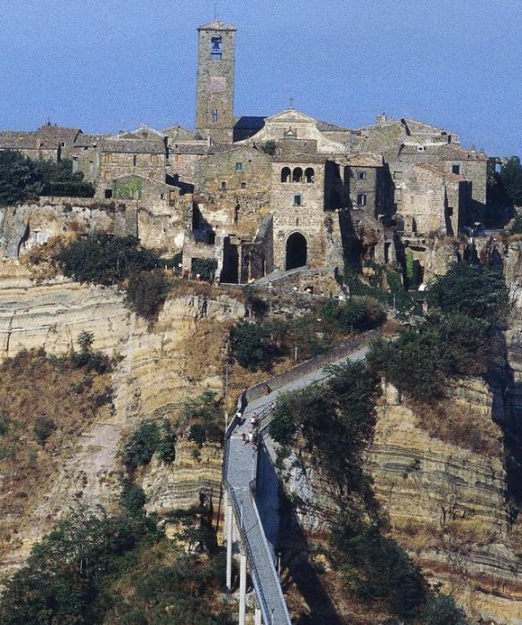 Fra i calanchi erosi dal tempo, Civita di Bagnoregio si erge su uno sperone di roccia, unita al mondo solo da un lungo e stretto ponte. Frane e terremoti hanno fatto di questo borgo fragile e pittoresco tra i guadi del Tevere e il lago di Bolsena una città fantasma.