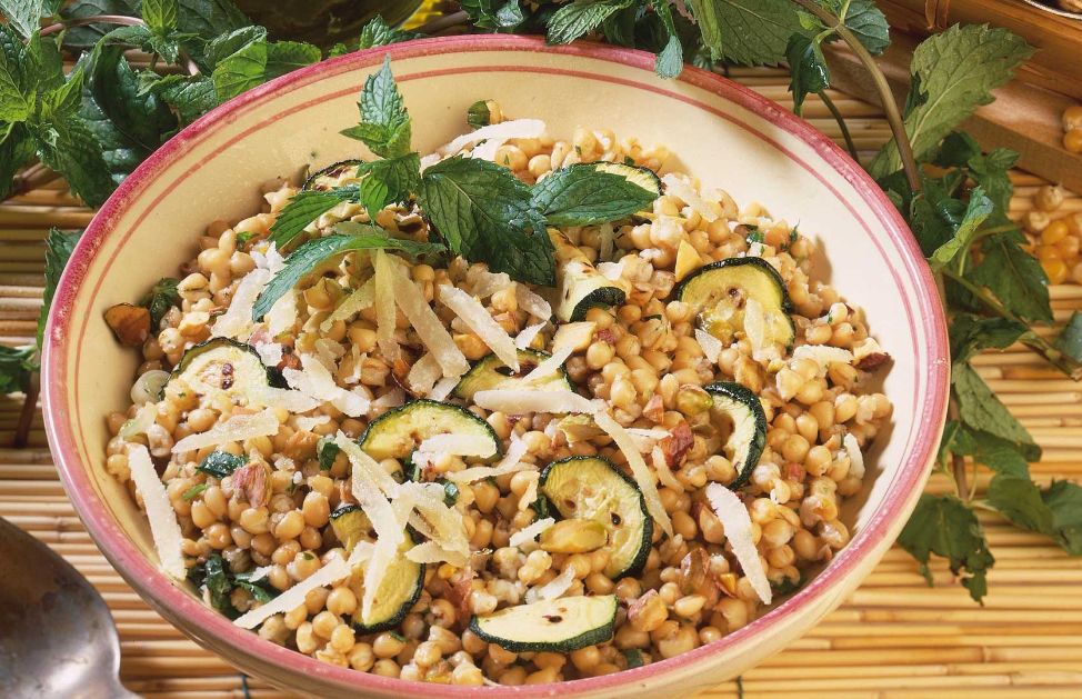 Prendete 400 g di broccoletti, puliteli, divideteli in cimette e lessateli, preferibilmente al vapore, per 10-15 minuti. Fate tostare 60 g di pistacchi sgusciati in un padellino antiaderente per circa un minuto, mescolando. Frullate i pistacchi con uno spicchio d'aglio sbucciato, 4 cucchiai di parmigiano grattugiato e una presa di sale, unendo a filo 6 cucchiai di olio EVO, fino a ottenere una crema. Frullate a parte i broccoletti, trasferite la purea ottenuta in un tegame antiaderente e fatela asciugare a fiamma vivace. Unite la crema di pistacchi e mescolate. Cuocete 400 g di penne al dente in una casseruola con abbondante acqua bollente salata, scolatele con cura, conditele in una terrina con la crema di broccoletti e pistacchi preparata, mescolate bene e servite.