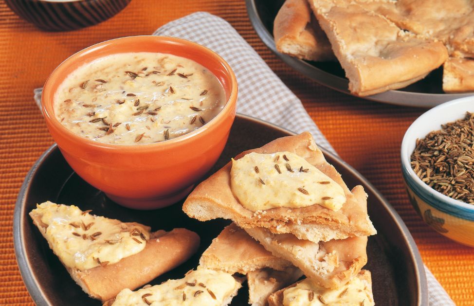 Un piatto di kamut accompagnato con porri e salsiccia alla curcuma