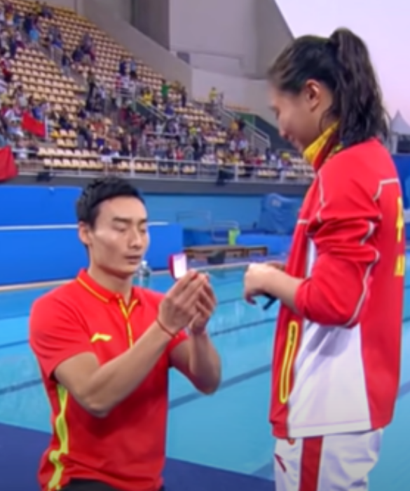 <p>Facciamo un salto temporale di 5 anni: siamo alle Olimpiadi del 2016 di Rio e l’atleta cinese He Zi vince la finale di trampolino da 3 metri, mentre Tania Cagnotto si aggiudica l’argento. Il tuffatore Qin Kai festeggia insieme a lei inginocchiandosi e chiedendole di sposarlo con tanto di anello.</p>